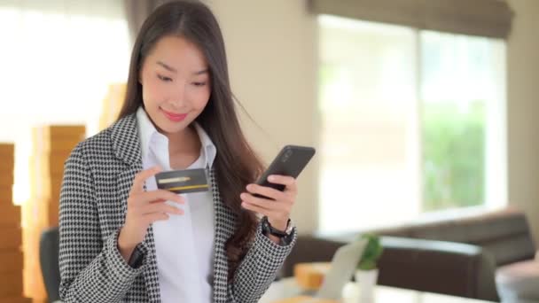 Beeldmateriaal Van Mooie Aziatische Zakenvrouw Shoppen Met Smartphone Creditcard Thuis — Stockvideo