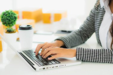 Güzel Asyalı iş kadını portresi evden bilgisayarlı cep telefonuyla karton kutuyla çevrimiçi alışveriş için hazır bekliyor.