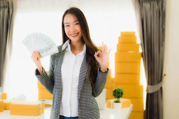 オンライン顧客ショッピングの出荷のための準備ができてラップトップの現金と段ボール箱と自宅から肖像画の美しい若いアジアの女性の仕事 — ストック写真