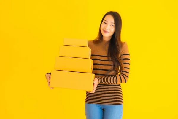 Piękna Młoda Azjatycka Kobieta Trzyma Kartonowe Pudełko Dłoni Żółtym Odizolowanym — Zdjęcie stockowe