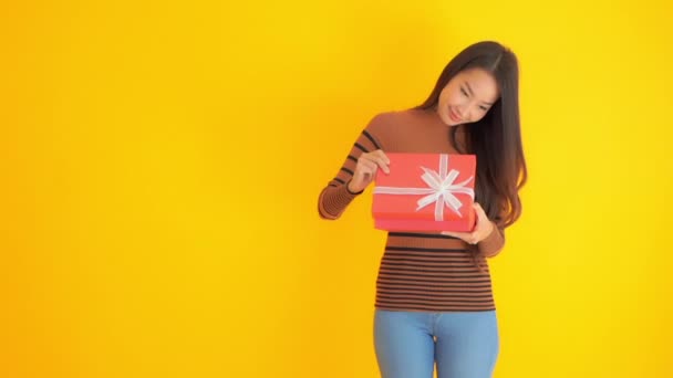 Footage Beautiful Asian Woman Holding Gift Box Isolated Yellow — Stock Video