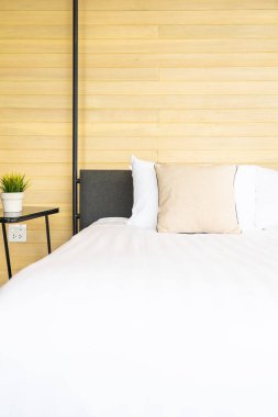 Otel odasındaki yatak odasının iç dekorasyonunda beyaz rahat yastık.