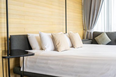 Otel odasındaki yatak odasının iç dekorasyonunda beyaz rahat yastık.