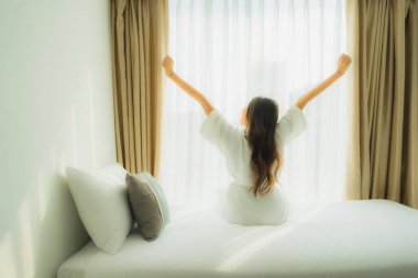 Genç Asyalı mutlu gülümseme. Yatak odasında iç tarafta rahatla.