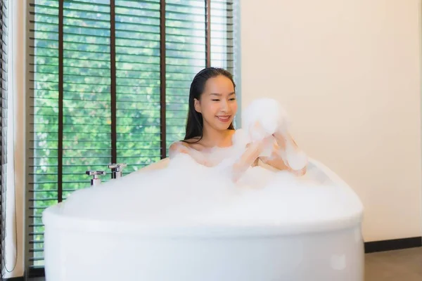 Portrait beautiful young asian woman happy smile relax take a bath in bathtub of bathroom interior