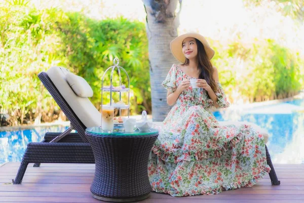 美しい肖像画若いアジアの女性と午後のお茶セットコーヒーはホテルリゾートのプールの周りの椅子に座る — ストック写真
