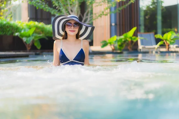 ポートレート美しい若いアジアの女性は休暇中のレジャーのためにホテルのリゾートでスイミングプールの周りリラックス — ストック写真