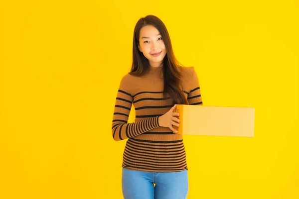 Όμορφη Νεαρή Ασιάτισσα Που Κρατάει Χαρτόκουτο Στο Χέρι Της Κίτρινο — Φωτογραφία Αρχείου