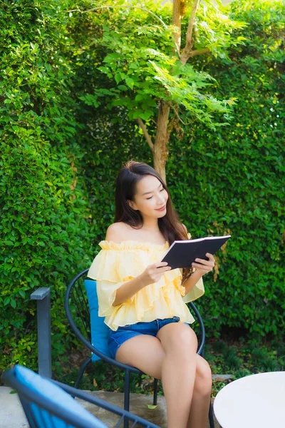 年轻的亚洲女人阅读关于室外花园自然景观的书籍 — 图库照片