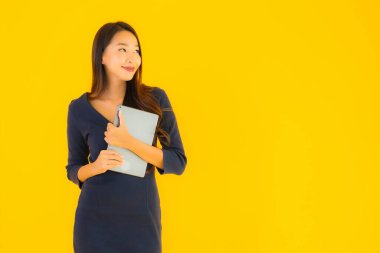 Sarı izole arka planda akıllı tabletli güzel Asyalı kadın portresi.