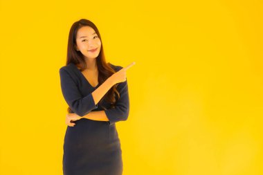 İzole edilmiş sarı arka planda hareketli güzel Asyalı kadın portresi.