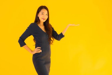 İzole edilmiş sarı arka planda hareketli güzel Asyalı kadın portresi.