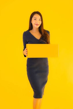 Karton paketli güzel Asyalı kadın, sarı izole edilmiş arka planda nakliyeye hazır.