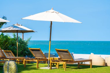 Şemsiye ve sandalye deniz kıyısında seyahat için.