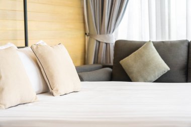 Otel odasındaki yatak odasının iç dekorasyonunda beyaz rahat yastık.