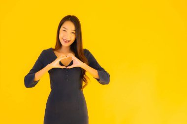 İzole edilmiş sarı arka planda hareketli güzel Asyalı kadın portresi.