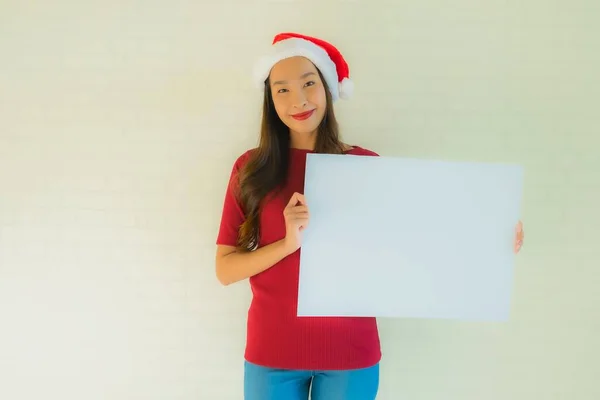 ポートレート美しい若いアジアの女性は サンタクリスマスの帽子を着用コピースペースと空白のホワイトボードカードを表示 — ストック写真