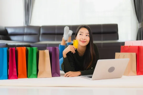 亚洲年轻貌美的女人 带着购物袋和信用卡 带着手机在家网上购物 — 图库照片