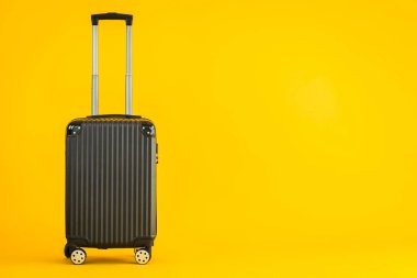 Sarı izole arka planda siyah renkli valiz ya da bagaj çantası kullanımı