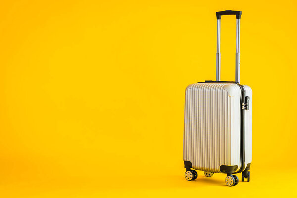 Gray color luggage or baggage bag use for transportation travel and leisure on yellow isolated background