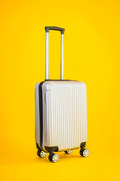 Gray color luggage or baggage bag use for transportation travel and leisure on yellow isolated background
