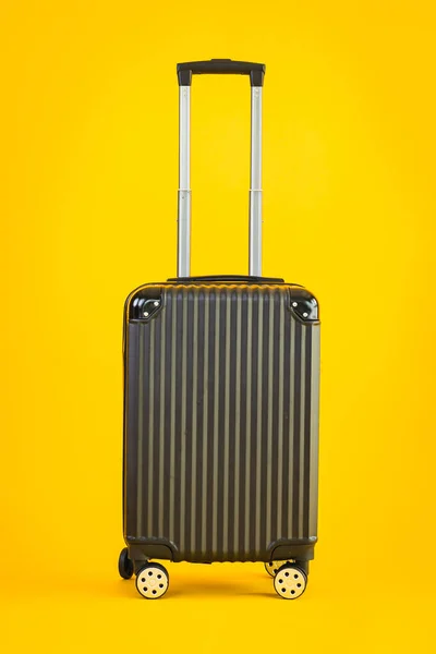Black color luggage or baggage bag use for transportation travel and leisure on yellow isolated background