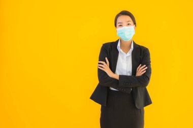 Güzel genç iş kadını portresi Korunmak için maske takıyor 19 koronavirüs sarı izole arka planda