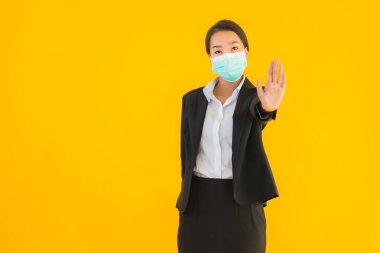 Güzel genç iş kadını portresi Korunmak için maske takıyor 19 koronavirüs sarı izole arka planda