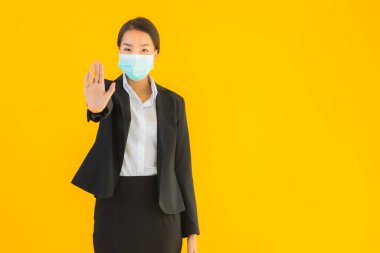 Güzel genç iş kadını portresi Korunmak için maske takıyor 19 koronavirüs sarı izole arka planda