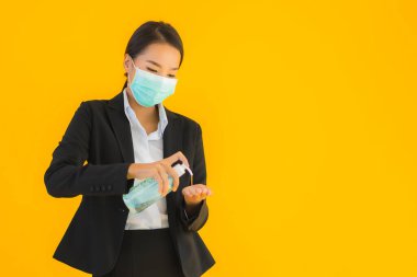 Güzel bir iş kadını portresi. Maske takıyor. Korunmak için alkol jeli kullanıyor.