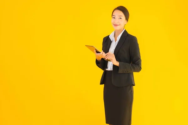 肖像画美しい若いアジアの女性幸せな笑顔とともにスマートタブレットデバイス上の黄色隔離された背景 — ストック写真