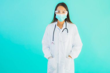 Klinikte ya da hastanede maske takmış güzel Asyalı genç doktor kadın portresi.