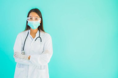 Klinikte ya da hastanede maske takmış güzel Asyalı genç doktor kadın portresi.