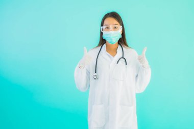 Klinikte ya da hastanede maske takmış güzel Asyalı genç doktor kadın portresi.