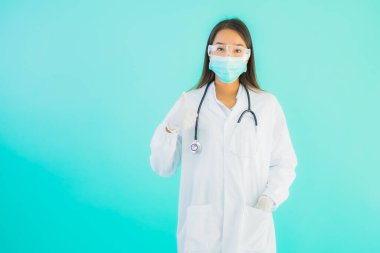 Klinikte ya da hastanede maske takmış güzel Asyalı genç doktor kadın portresi.