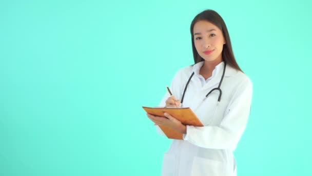ターコイズで隔絶されたクリップボードを持つ美しいアジア系女性医師の映像 — ストック動画