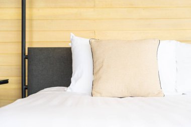 Otel odasındaki yatak odasının iç dekorasyonunda beyaz rahat yastık.