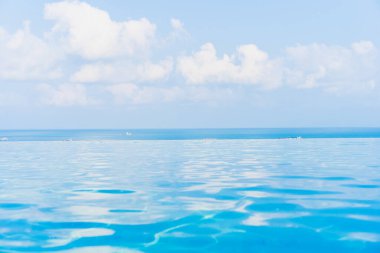 Okyanus manzaralı güzel sonsuzluk yüzme havuzu beyaz bulut mavi gökyüzü boş bir tatil için