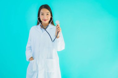 Klinikte ya da mavi izole edilmiş arka planda hastanede kullanmak üzere steteskoplu güzel Asyalı genç doktor kadın portresi.