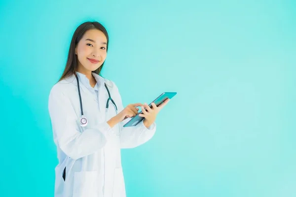 带听诊器和灵巧石碑的美丽年轻亚洲医生妇女的画像 供医院和诊所在蓝色隔离背景下使用 — 图库照片