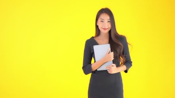 Metraje Hermosa Mujer Asiática Sosteniendo Tableta Mirando Cámara Aislada Amarillo — Vídeos de Stock