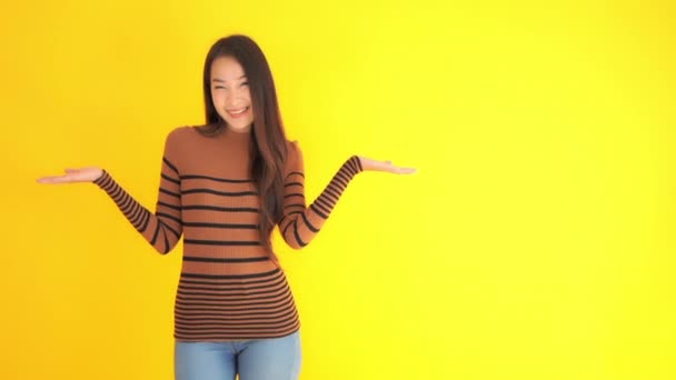 Imagens Bela Mulher Asiática Apontando Espaço Branco Isolado Amarelo — Vídeo de Stock