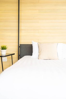 Otel odasındaki yatak odasının iç dekorasyonunda beyaz rahat yastık.