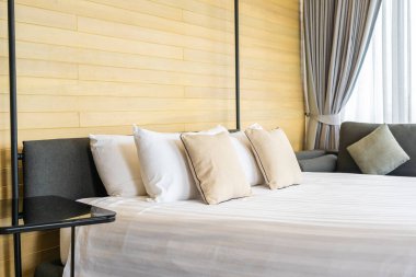 Otel odasındaki yatak odasının iç dekorasyonunda beyaz rahat yastık.