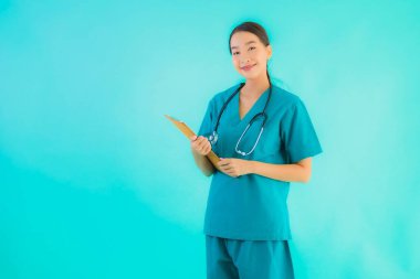 Fotokopi için boş kâğıt tahtası olan güzel Asyalı genç doktor kadın hastane ve klinikteki sağlık hizmetleri konseptinde mavi izole edilmiş arka plan.