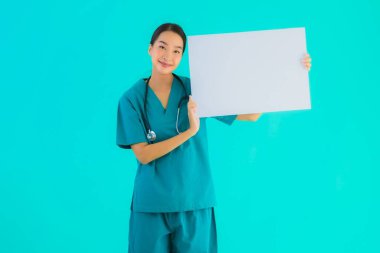 Fotokopi için boş kâğıt tahtası olan güzel Asyalı genç doktor kadın hastane ve klinikteki sağlık hizmetleri konseptinde mavi izole edilmiş arka plan.