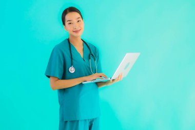 Mavi izole arka planda dizüstü bilgisayarı olan güzel Asyalı doktor kadın portresi.