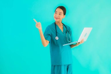 Mavi izole arka planda dizüstü bilgisayarı olan güzel Asyalı doktor kadın portresi.