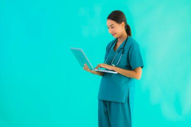 Mavi izole arka planda dizüstü bilgisayarı olan güzel Asyalı doktor kadın portresi.