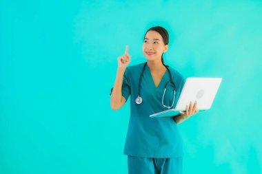 Mavi izole arka planda dizüstü bilgisayarı olan güzel Asyalı doktor kadın portresi.